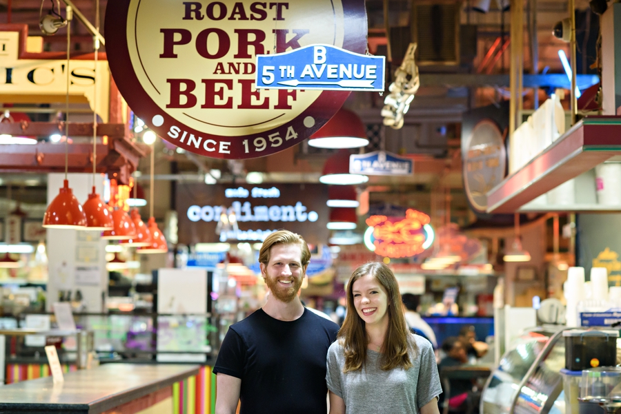 An engaged couple standing in Reading Terminal Market in Philadelphia during thier engagement Session.